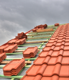 Partially tiled roof with stacks of tiles placed on it